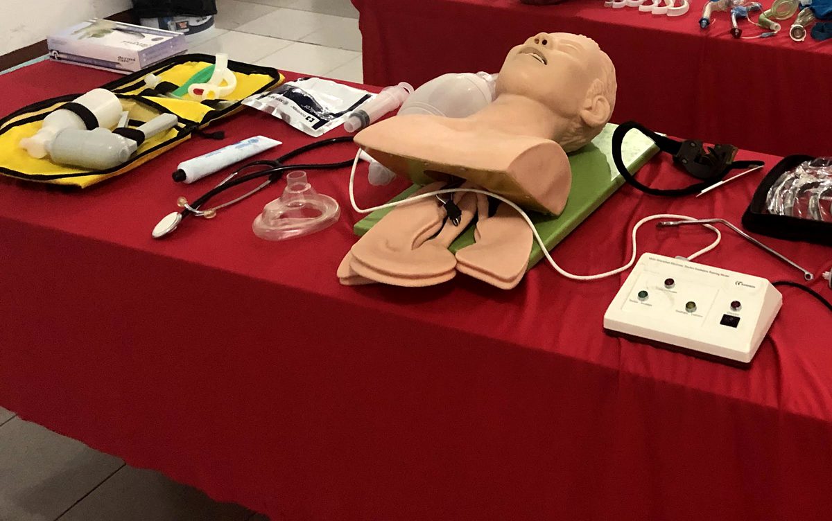 Mesa con simulador de intubación, laringoscopio, cánulas y tubos endotraqueales.