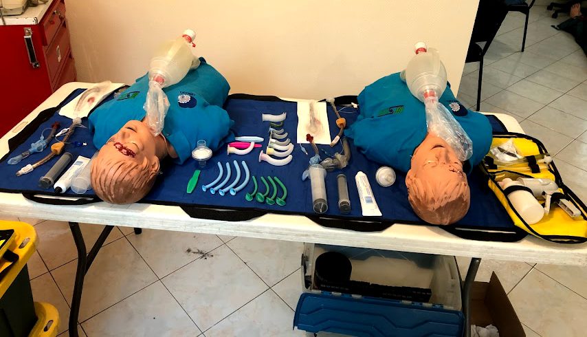 Dos maniquíes de vía aérea sobre una mesa con cánulas, bolsas-mascarilla y equipo.