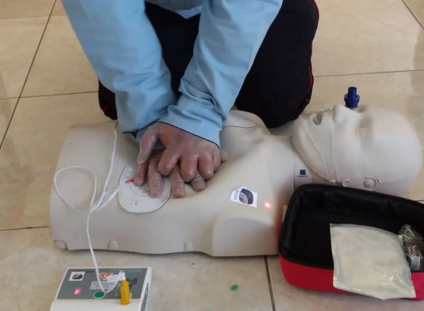Compresiones torácicas en un maniquí de adulto con los parches del DEA de entrenamiento colocados.