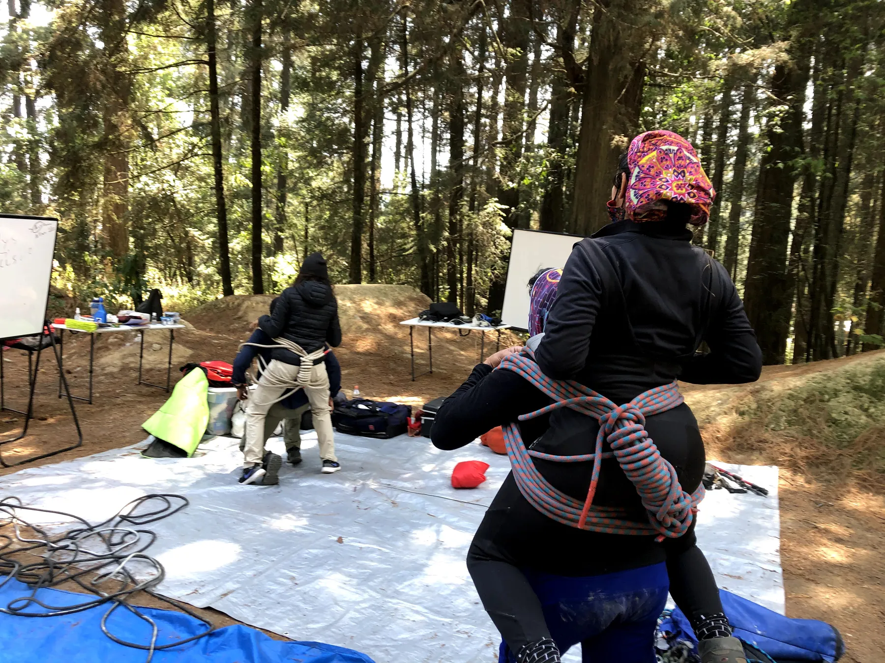 Traslado a cuestas con una silla hecha de cuerda, de espaldas, en el bosque.